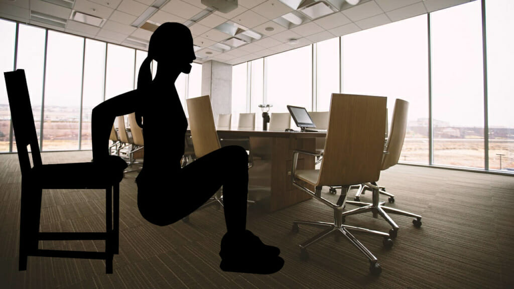 Frau beim Dip Training auf einem Stuhl - Im Hintergrund Roundtable am Arbeitsplatz
