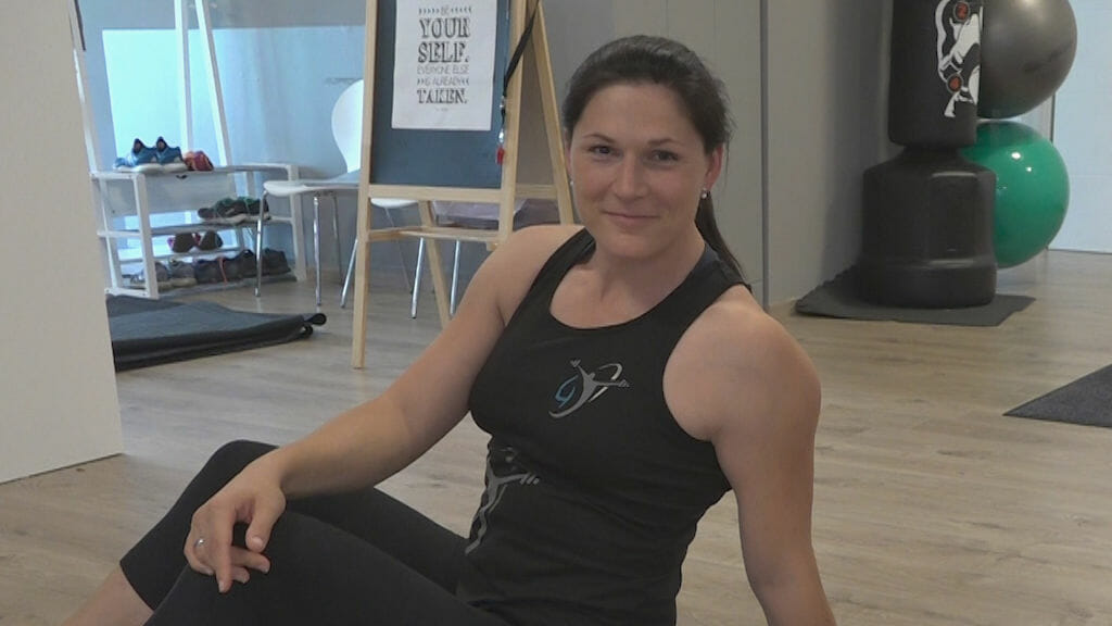 Sabine Kunze auf dem Boden sitzend im Trainingsraum