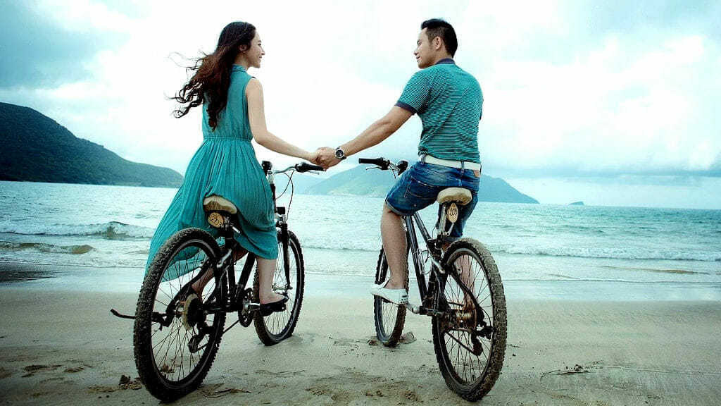 Liebespaar mit Fahrrad am Meer