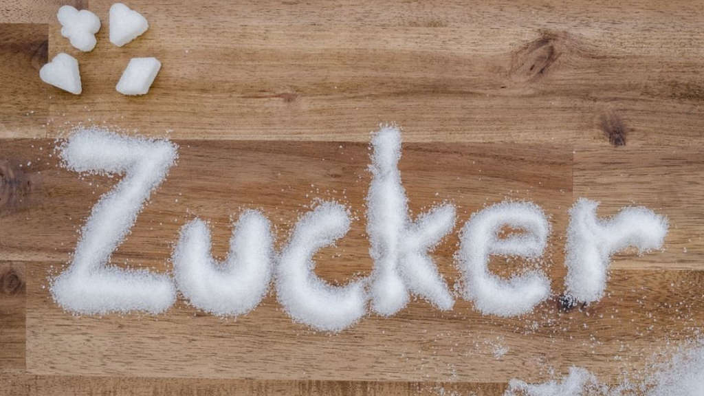 Weißer Haushaltszucker, der den Schriftzug "Zucker" formt